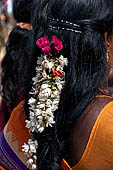 Scented garlands of fresh flowers swaying in women black hair near the Swamimalai temple. 